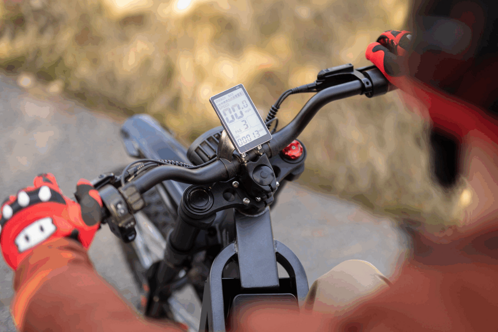 Close-up of a person riding a bike with a digital display on the handlebars, blurred background